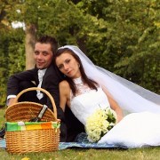 fotografia ślubna: państwo młodzi siedzą na trawie